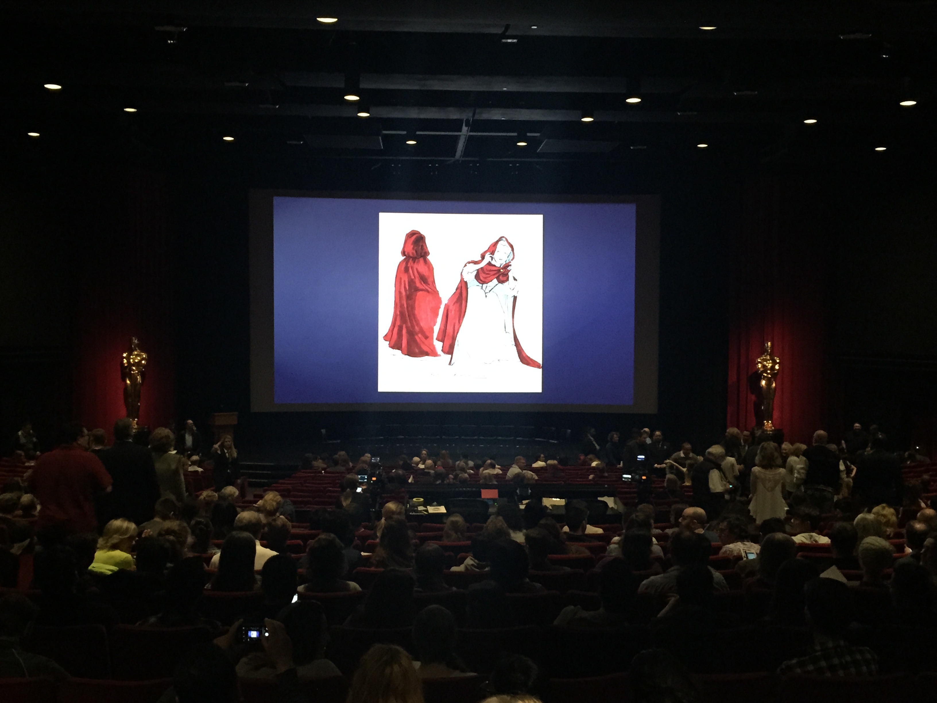 Production art was shown on the screen as the audience filled the theater.