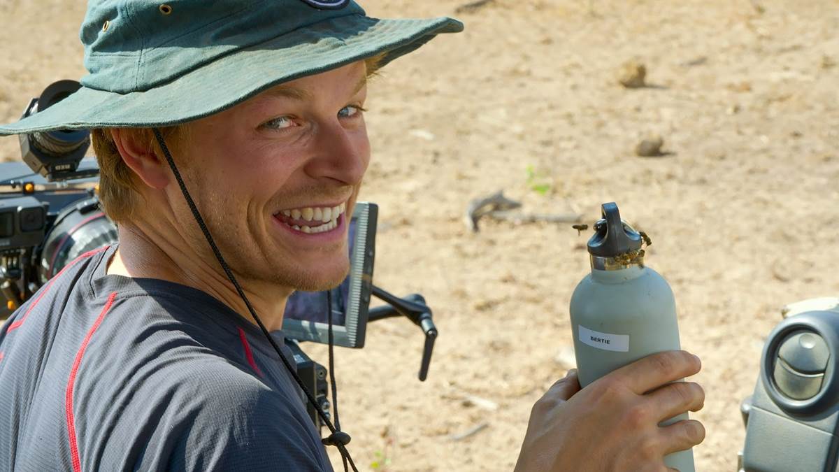Bertie Gregory hydrating while filming in the Zambian sun. (Credit: National Geographic/George Pagliero for Disney+)
