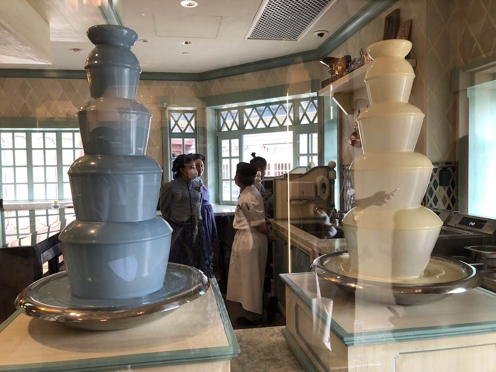 Blue and white chocolate fountains used to coat pastries